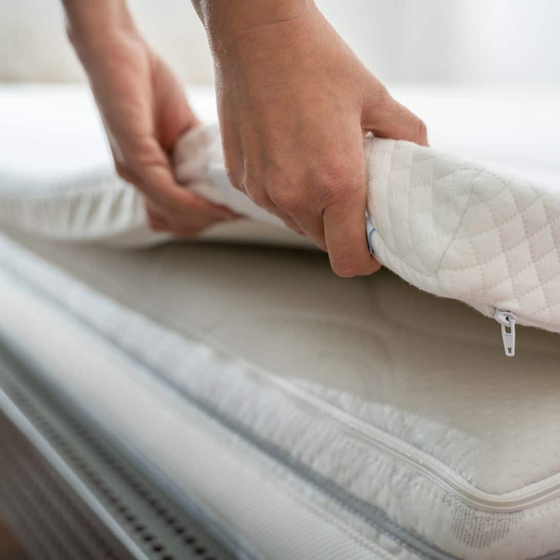 Aanpasbare topper wordt op matras gelegd