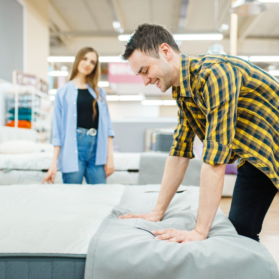 Man en vrouw testen Ikea matrassen in de winkel