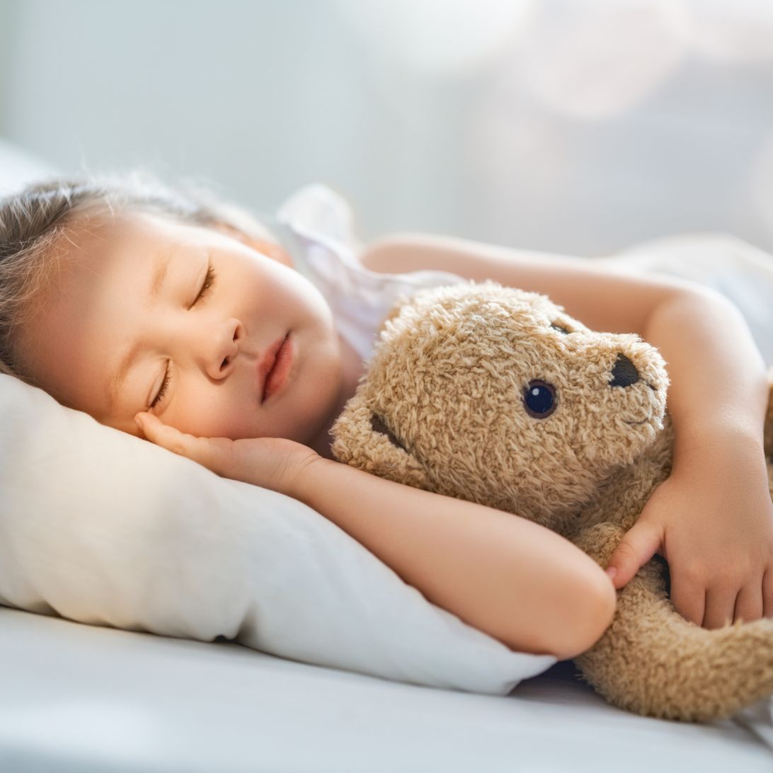 Kind slaapt met teddybeer op koudschuim kindermatras