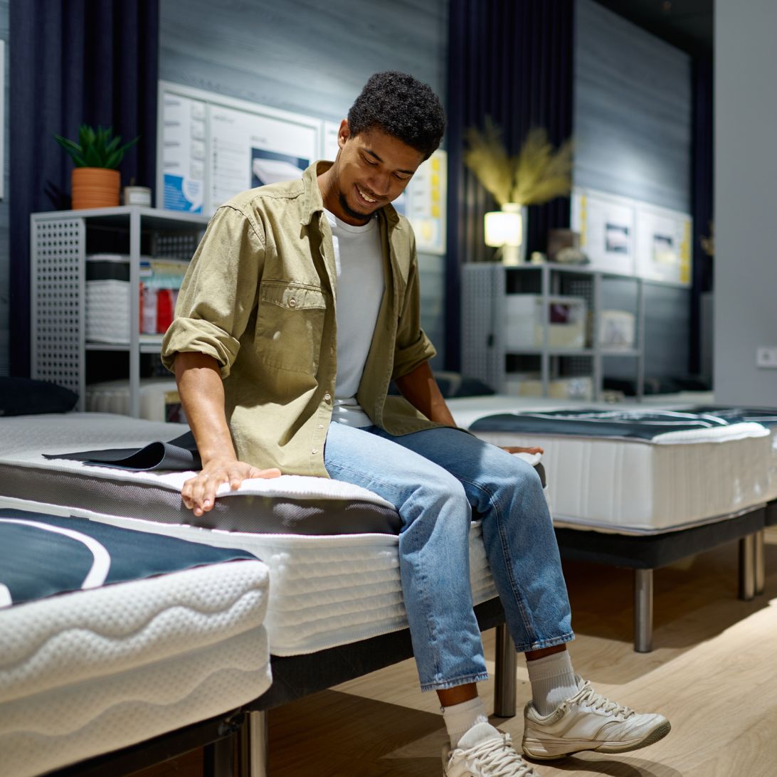 Man test matras in de winkel