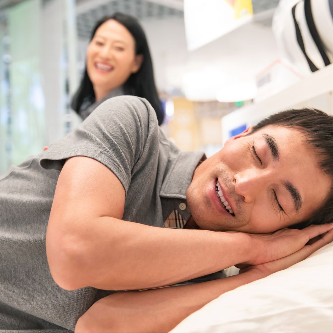 Man en vrouw proefliggen om het beste bed te vinden