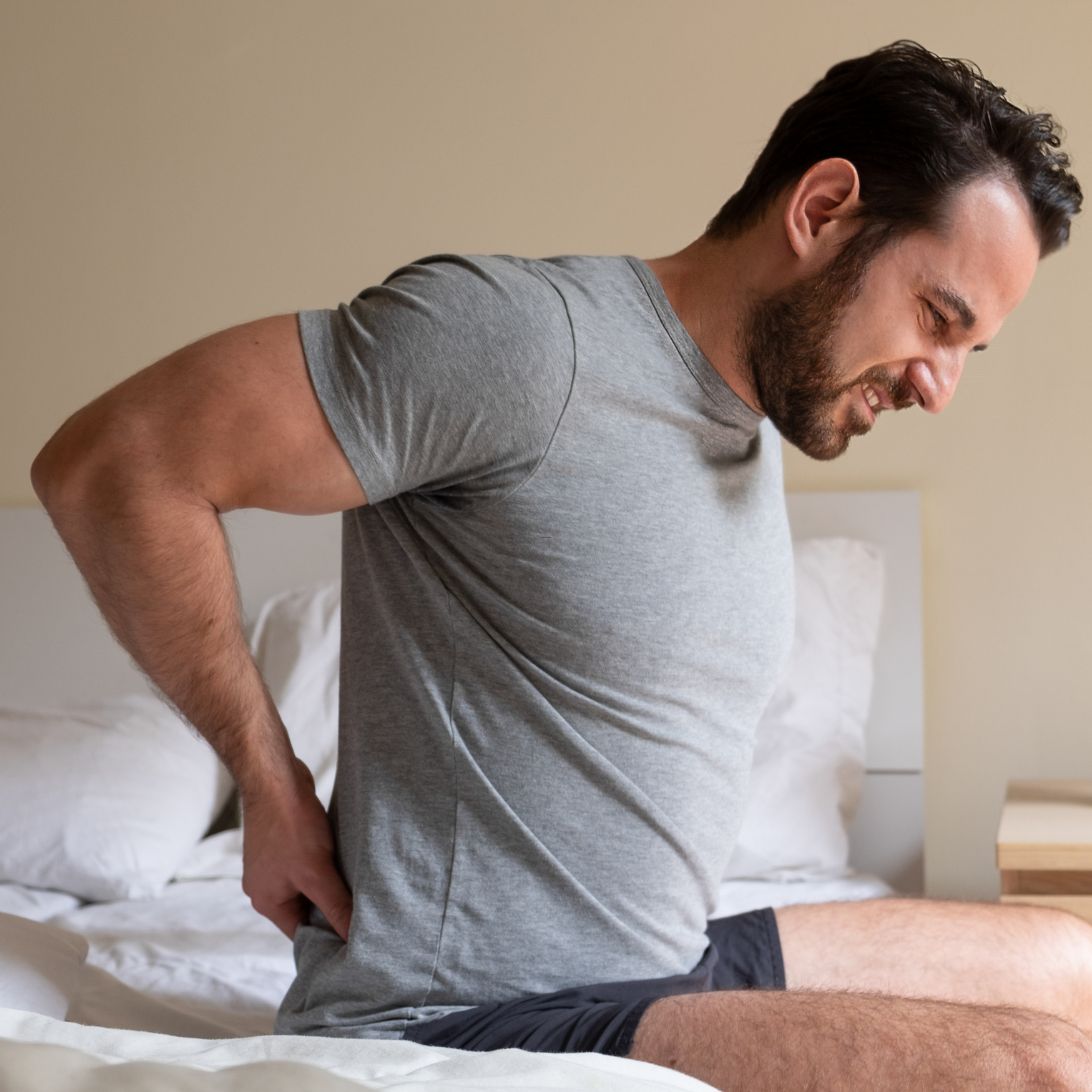 Man met rugklachten op matras