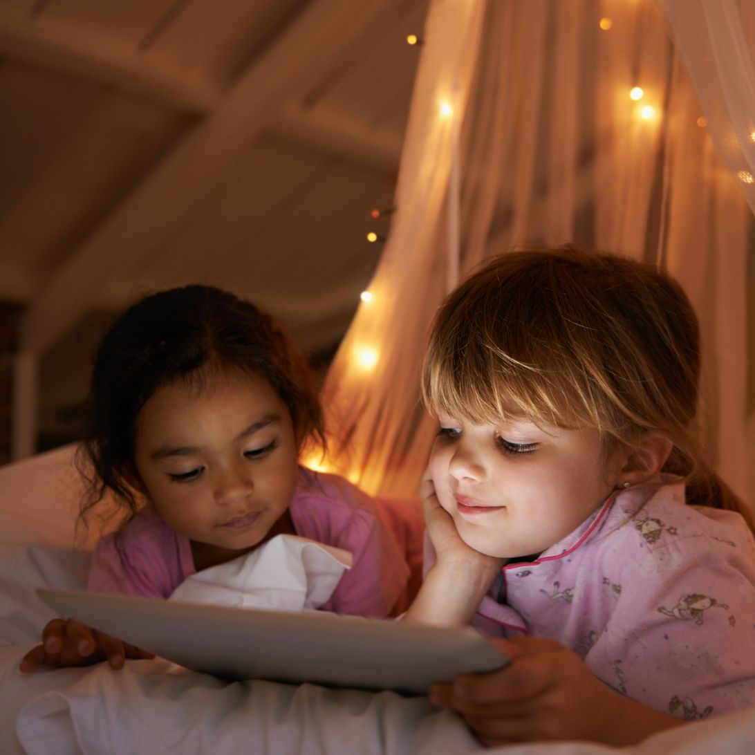 Twee kinderen gaan op tijd naar bed na de vakantie, dankzij een boekje lezen voor het slapen