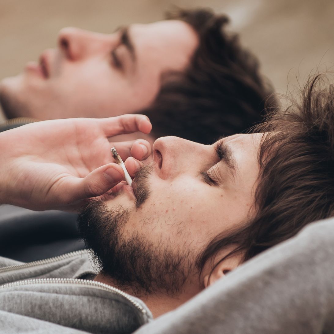 Twee mannen roken een jointje voor het slapen gaan, terwijl wiet juist een negatieve invloed op slaap kan hebben