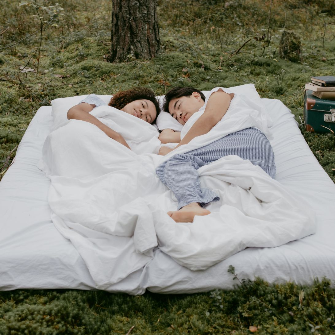 Vrouw en man liggen in het bos op een milieuvriendelijk matras