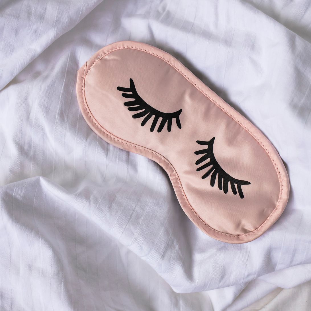 Sneller slapen met een slaapmasker (roze met zwarte wimpers erop)