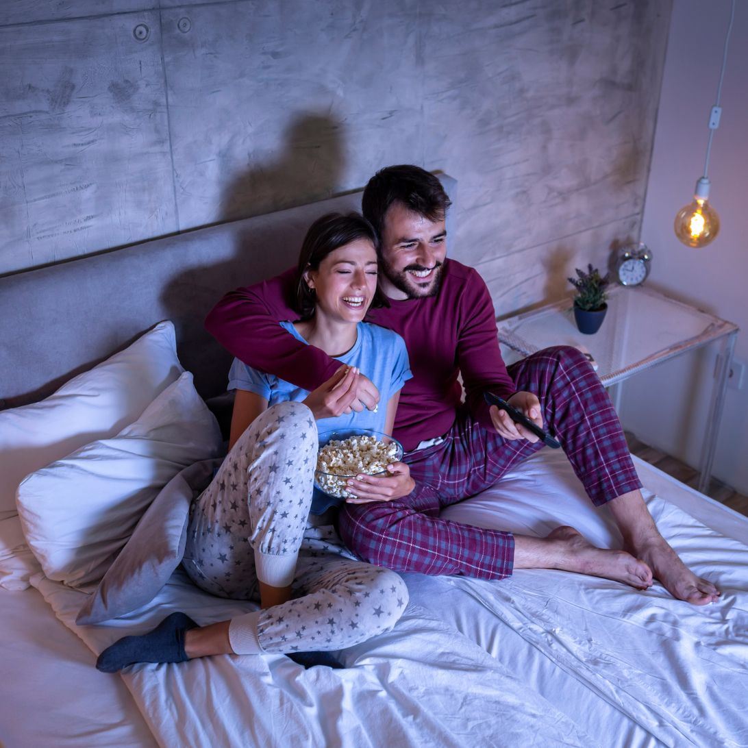 Man en vrouw kijken in bed televisie op boxspring met tv-lift