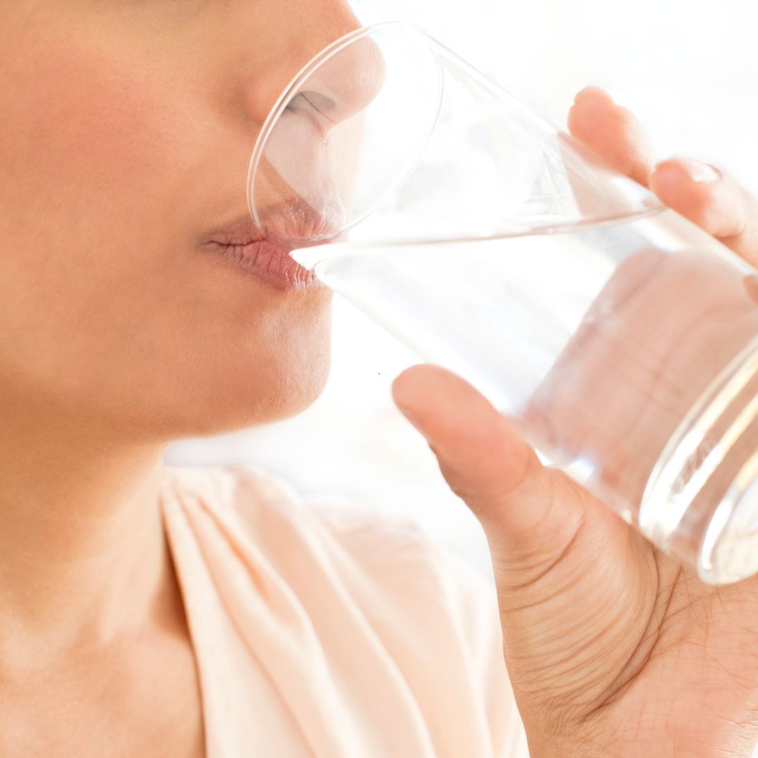 Vrouw hydrateert genoeg voor het slapen gaan, hydratatie belangrijk voor slaapkwaliteit