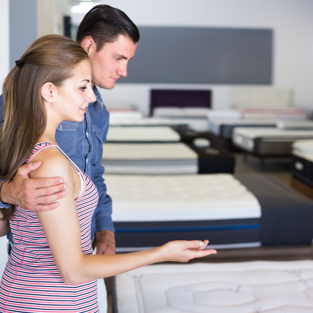 Man en vrouw zoeken beste matrasdeal in matrassenwinkel