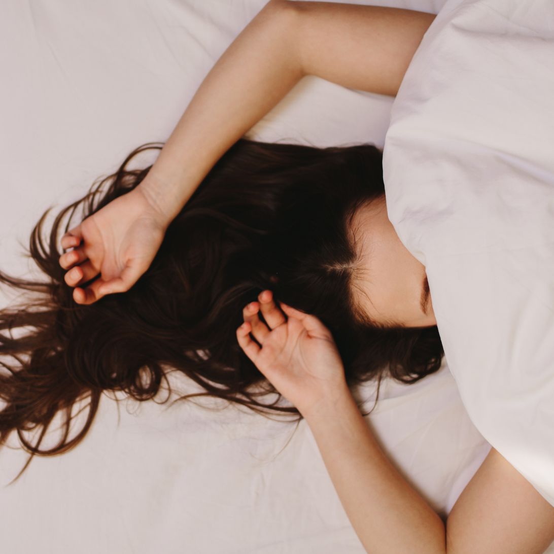 Vrouw ligt op haar rug op beste matras voor rugslapers