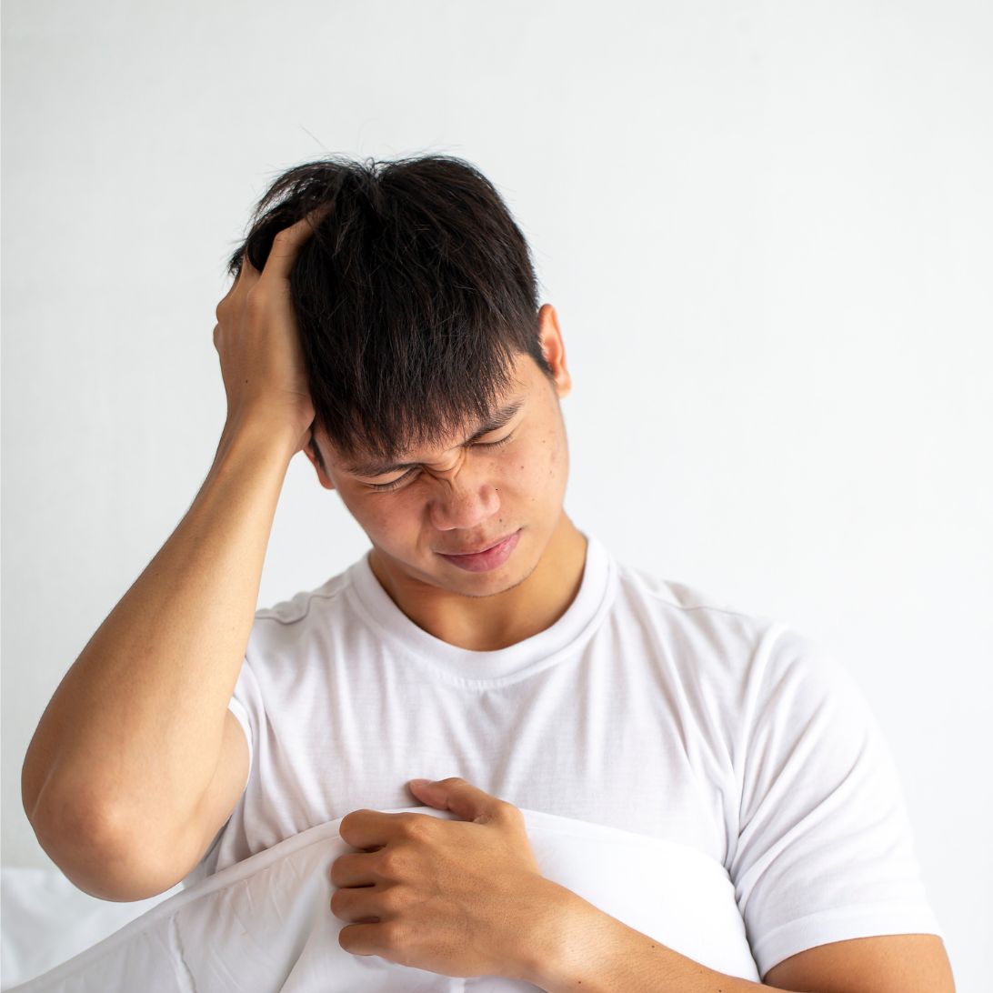 Man met hoofdpijn in bed