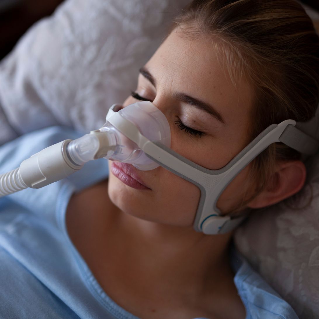 Vrouw gebruikt CPAP-apparaat tegen slaapapneu