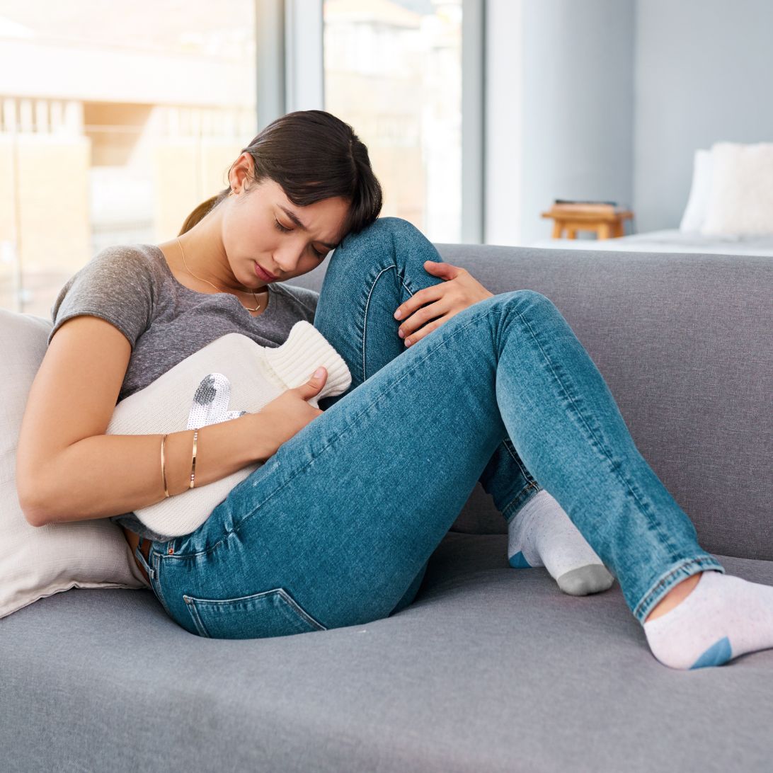 Vrouw houdt warmtekussen tegen buik