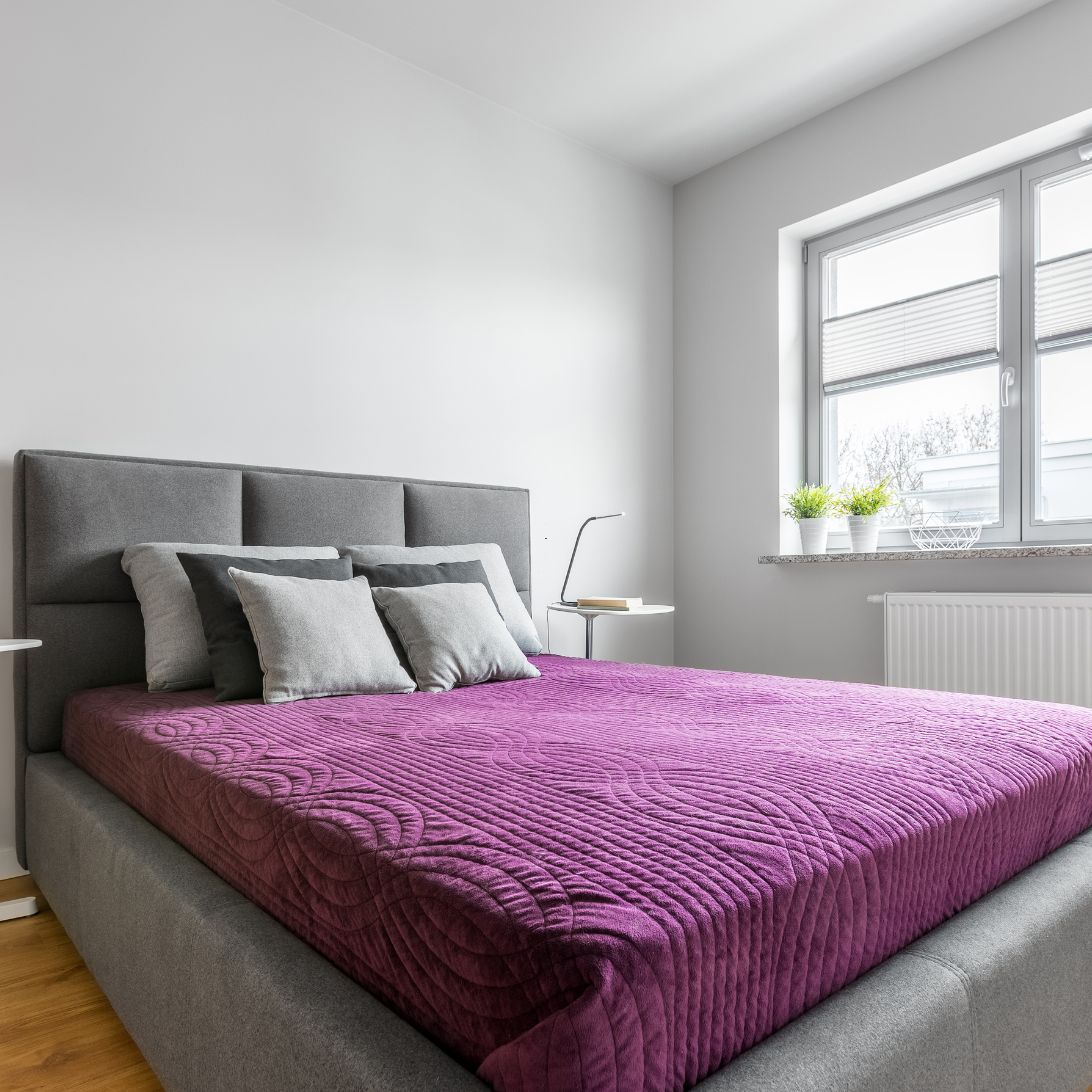 grijs, ,gestoffeerd bed, opgedekt met paars beddengoed