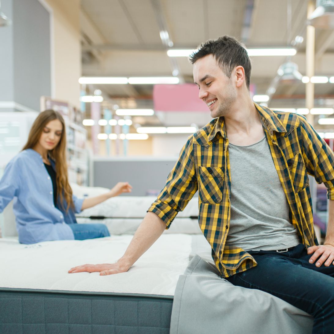 Mensen proberen en kopen nieuw matras in de winkel
