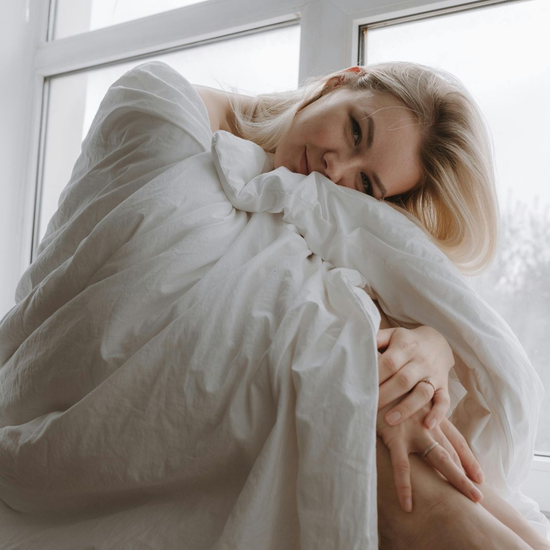 Vrouw is gewikkeld in beddengoed van Leen Bakker