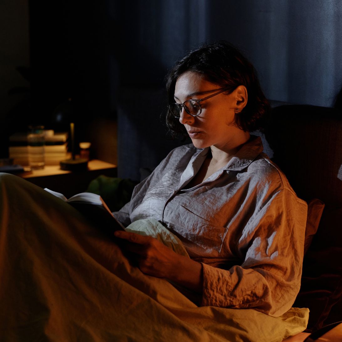 Elektrische lattenbodem 1 Vrouw is in bed aan het lezen dankzij omhoogstaande elektrische lattenbodem