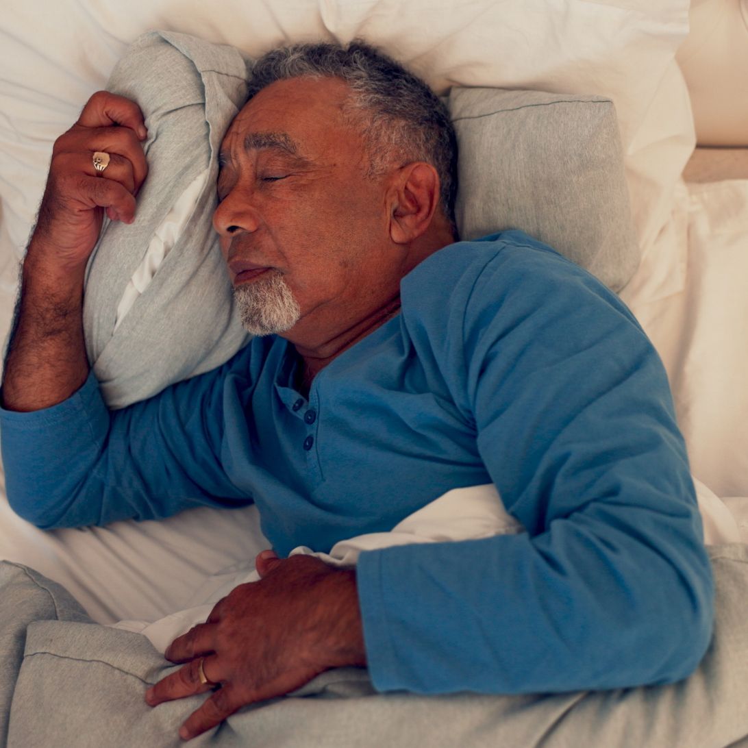 Oudere man ligt te slapen op hooglaagbed