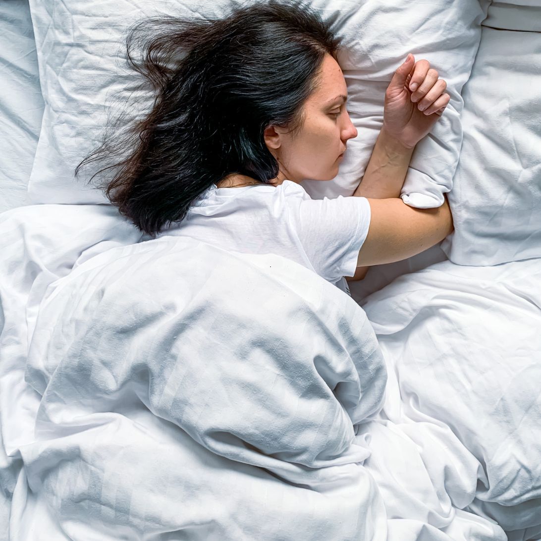 Vrouw ligt te slapen in bed van Hästens breda